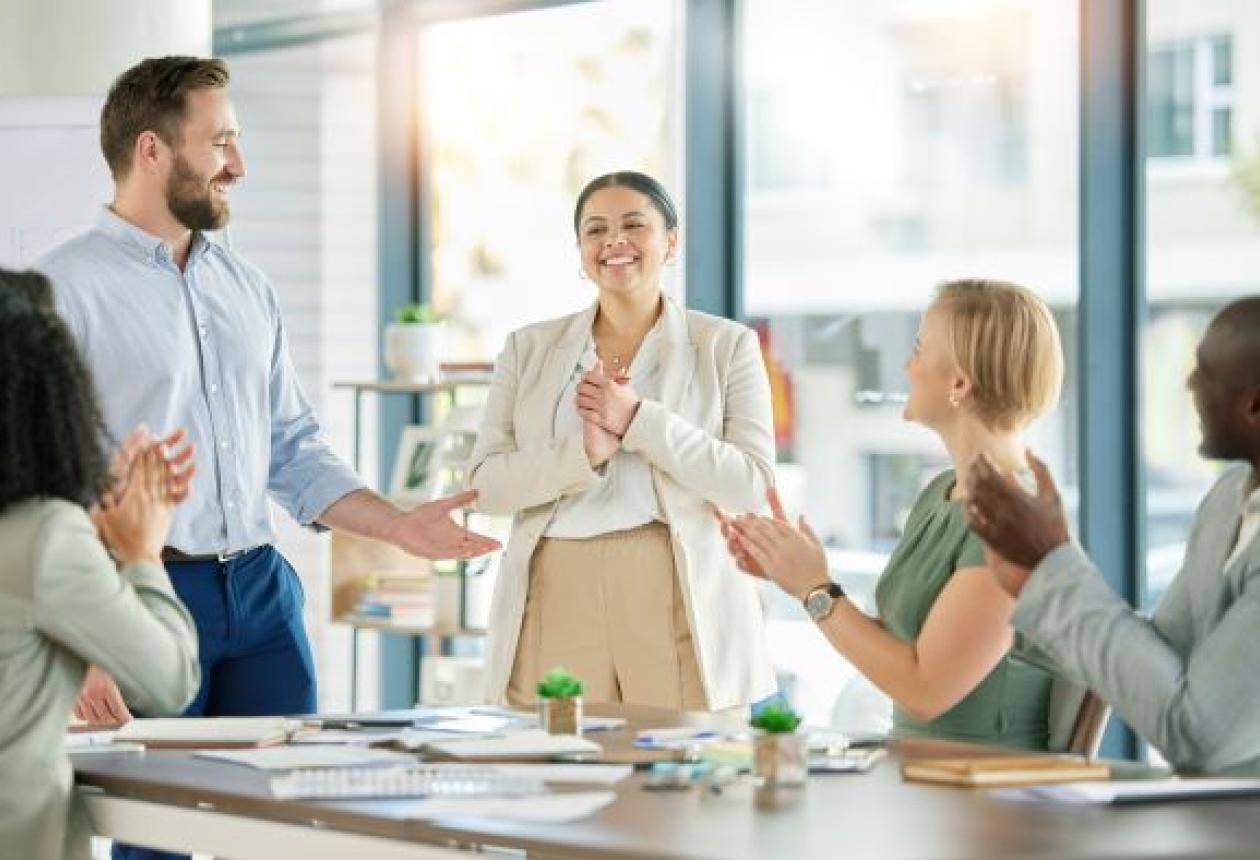 Une femme félicitée pour son travail par des collaborateurs