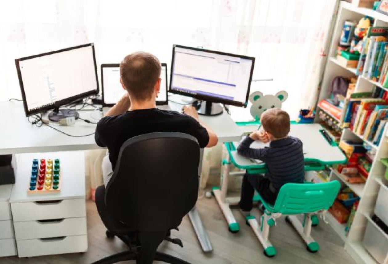Père avec son enfant en télétravail. Travailler depuis chez soi.